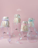 Fionka gourmet cake by Gateau Gourmet Cafe elegantly wrapped with pastel iridescent ribbons on clear acrylic stands