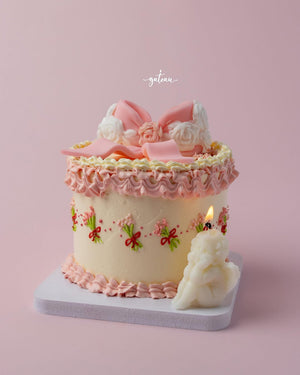 Fionka gourmet cake by Gateau Gourmet Cafe decorated with pink and white frosting and a small angel candle