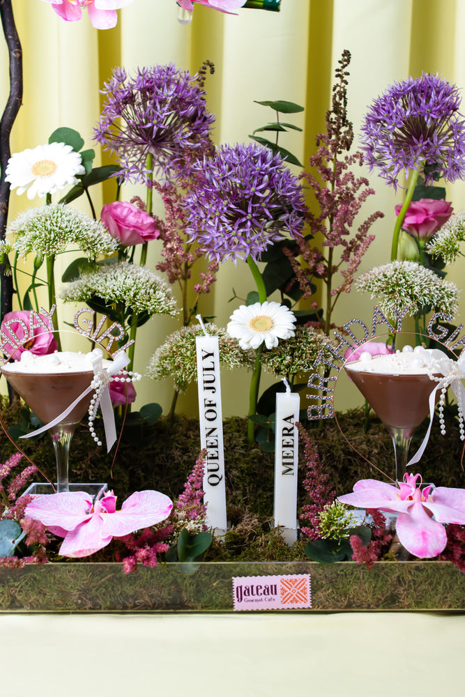 Floral birthday cake design from Gateau Gourmet Cafe surrounded by elegant flowers and celebratory decor