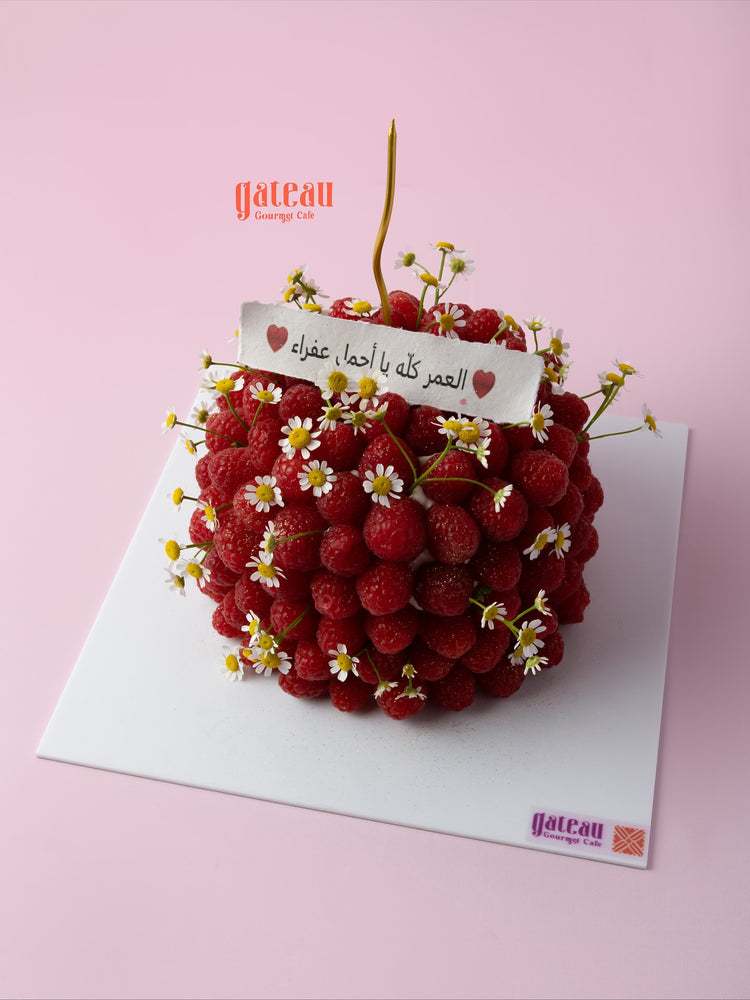 Fresh raspberry cake for delivery decorated with vibrant raspberries and delicate flowers