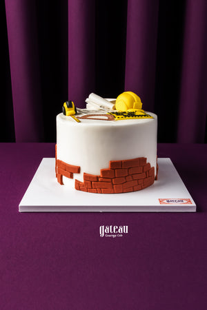 Architect themed cake by Gateau Gourmet Cafe with construction hat and blueprint decorations