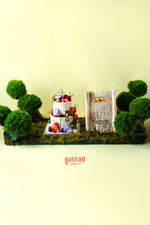 Creative artisan cakes near me by Gateau Gourmet Cafe decorated with fresh fruits and flowers surrounded by green moss and plants