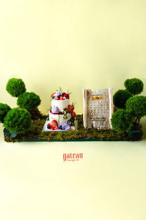 Creative artisan cakes near me by Gateau Gourmet Cafe decorated with fresh fruits and flowers surrounded by green moss and plants