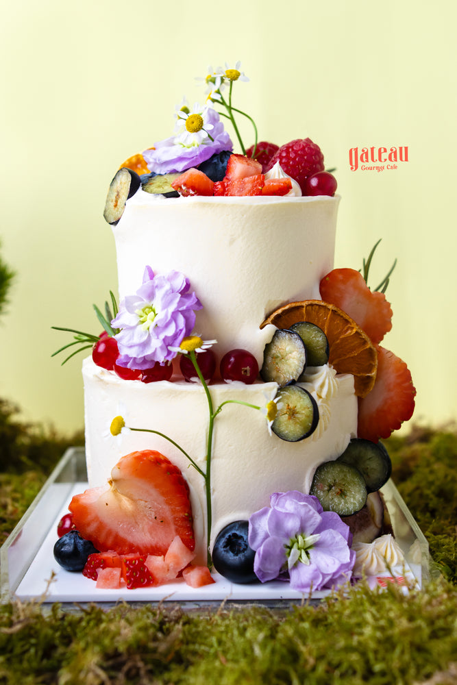 Two-tier artisan cake with fresh fruits and flowers by Gateau Gourmet Cafe perfect for artisan cakes near me