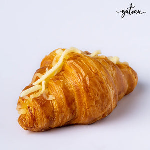 Golden flaky artisan cheese croissant topped with shredded cheese from Gateau Gourmet Cafe