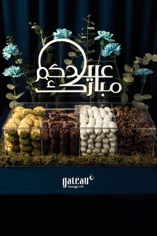 Elegant display of assorted-arabic-sweet-treats-w-arrangement from Gateau Gourmet Cafe with decorative flowers