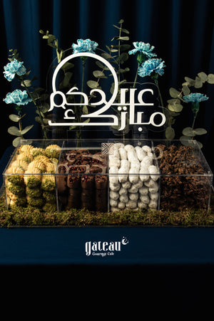 Elegant display of assorted-arabic-sweet-treats-w-arrangement from Gateau Gourmet Cafe with decorative flowers