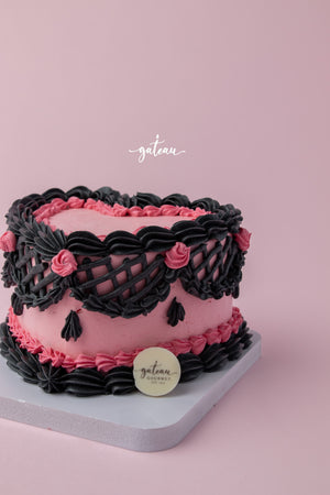 Gateau Gourmet Cafe Barbie theme birthday cake with pink and black decorative frosting on a white board