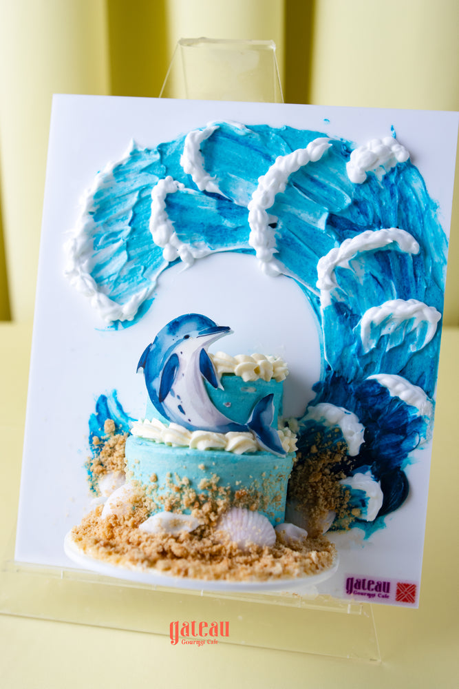 Beach themed birthday cake by Gateau Gourmet Cafe with blue waves dolphin and sand decoration