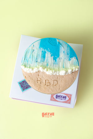 Beach themed goblet cake with blue icing and sandy bottom, decorated for a birthday celebration