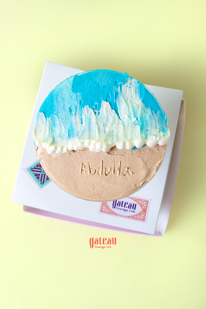 Beach themed goblet cake with blue icing and sand-like frosting from Gateau Gourmet Cafe