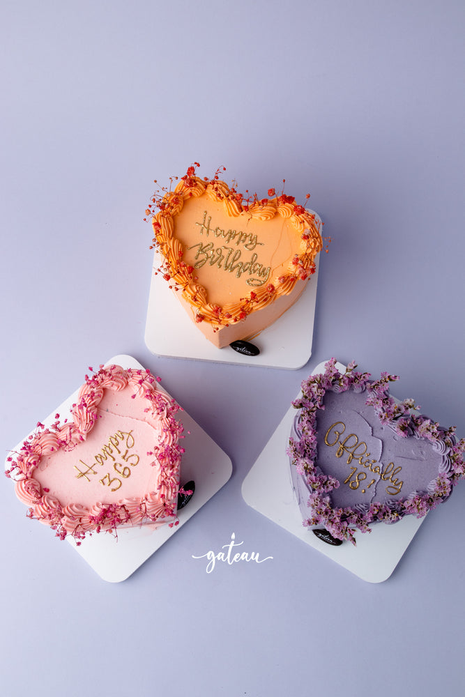 Three colorful heart-shaped cakes from Gateau Gourmet Cafe, perfect for birthday cake delivery service