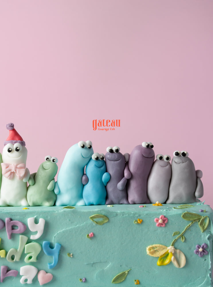 Colorful birthday cake for best friend topped with playful fondant figures at Gateau Gourmet Cafe