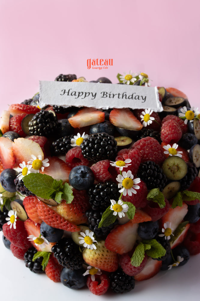 Delicious birthday cake with mixed berries topped with fresh strawberries and blackberries