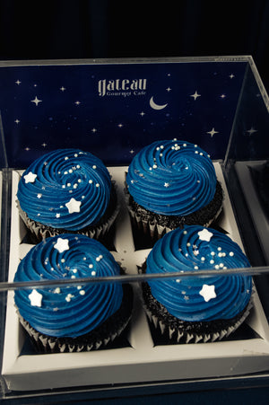 Gateau Gourmet Cafe blue frosted cupcakes for parties with star-shaped sprinkles in a display box
