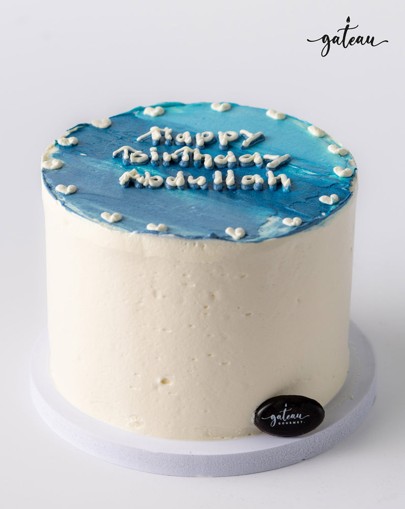 Blue ombre cake with white frosting and birthday message by Gateau Gourmet Cafe
