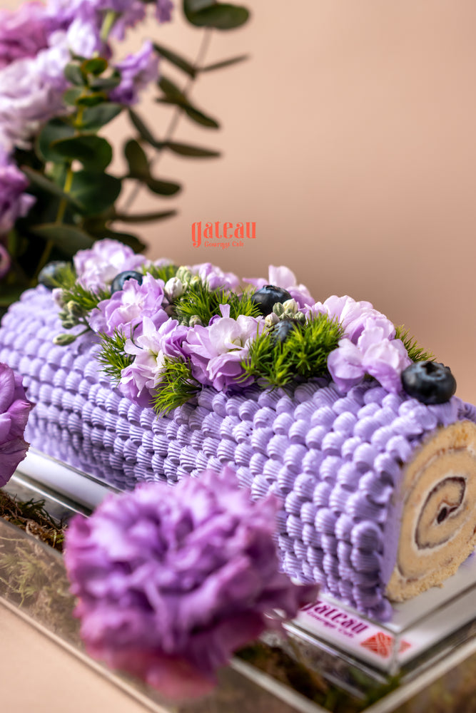 Blueberry cake floral arrangement with purple frosting and fresh flowers from Gateau Gourmet Cafe