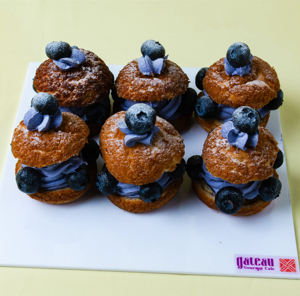 Gateau Gourmet Cafe choux with blueberry cream dessert and fresh blueberries on white tray