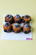 Gateau Gourmet Cafe choux filled with blueberry cream dessert topped with fresh blueberries on white board