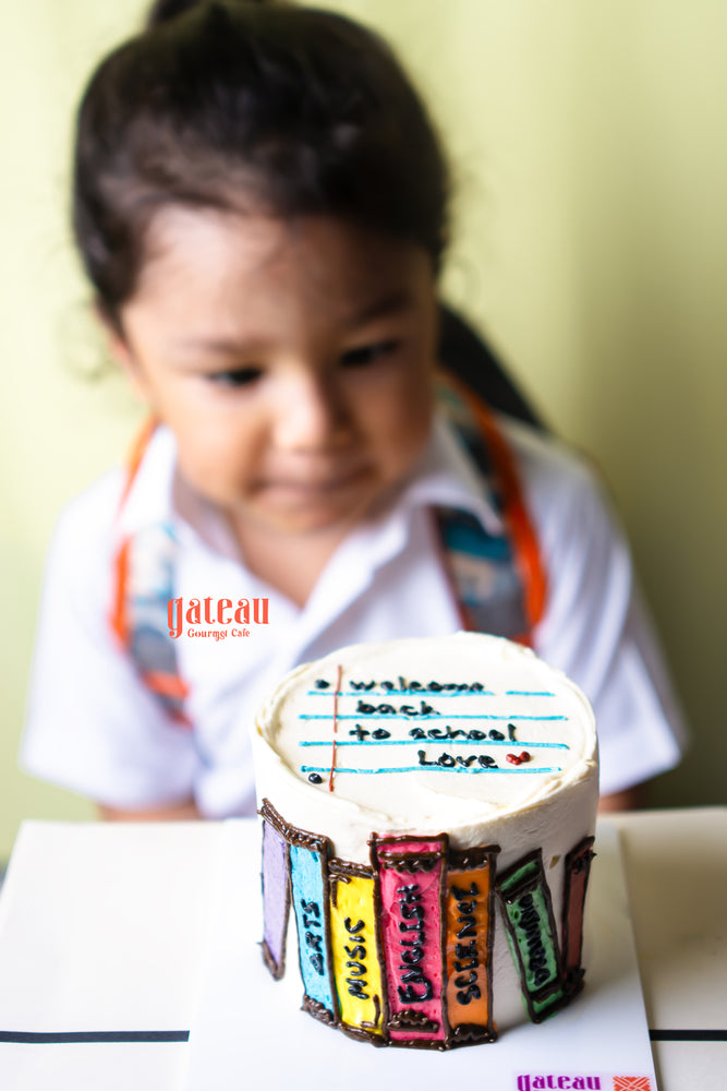 Colorful book stack mini cake decorated with school-themed details, perfect for back-to-school celebrations