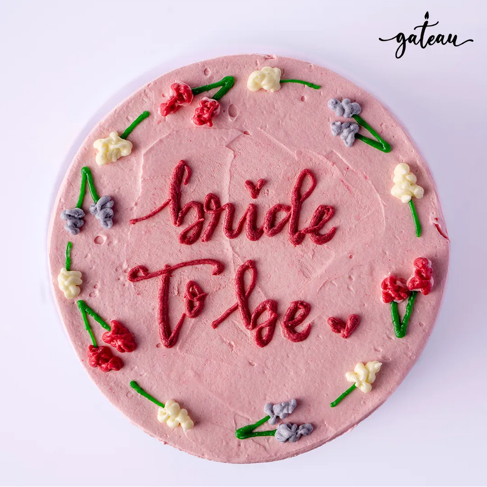 Pink frosted bride to be cake with colorful floral decorations from Gateau Gourmet Cafe