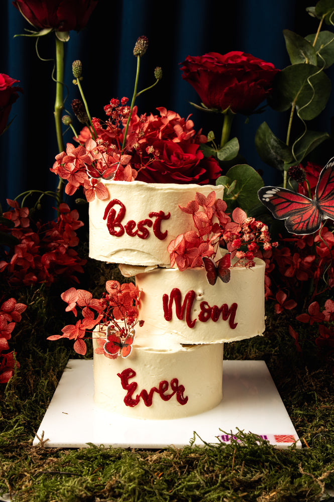 Cake Butterflies Red Garden themed three-tier white cake with red floral decorations and Best Mom Ever text