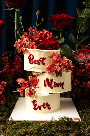 Cake Butterflies Red Garden themed three-tier white cake with red floral decorations and Best Mom Ever text