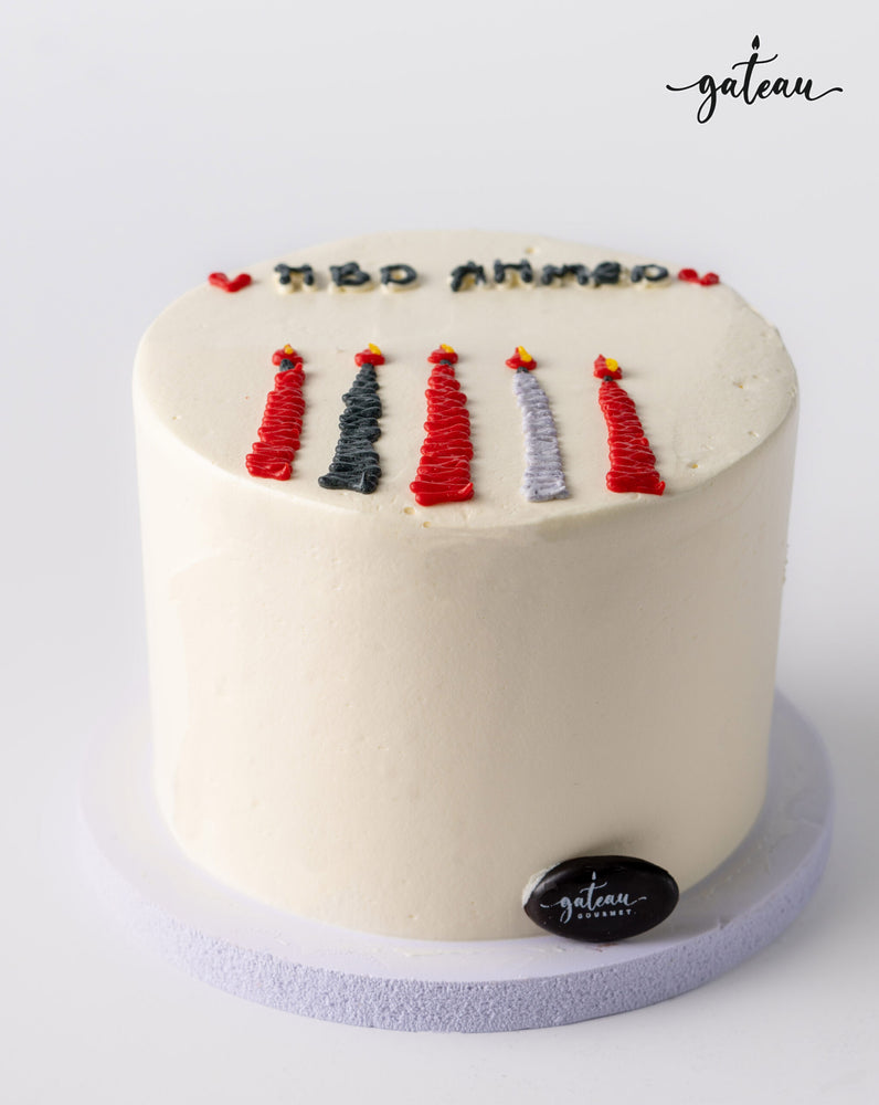 Minimalist white candle bundle cake with colorful candle decorations and happy birthday text