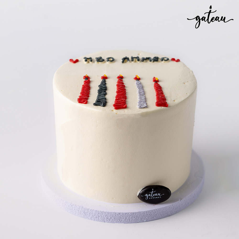 Gateau Gourmet Cafe candle bundle cake with white frosting and five colorful candle designs on top