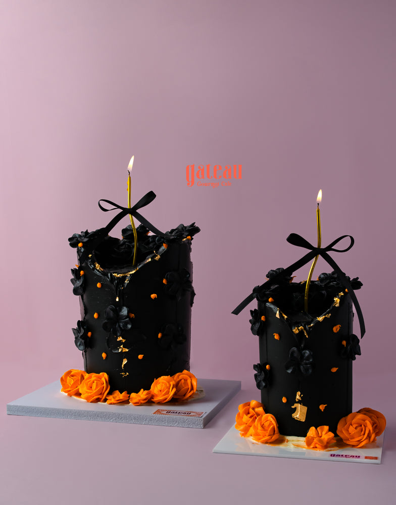 Elegant candle cake for celebrations decorated with black flowers and orange roses