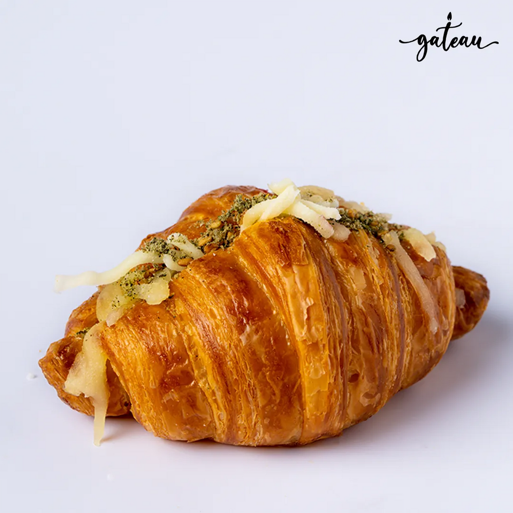 Cheese zaatar croissant with melted cheese and zaatar seasoning from Gateau Gourmet Cafe on white background