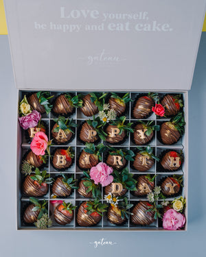 Gateau Gourmet Cafe chocolate covered strawberries arranged with flowers spelling happy birthday in a gift box