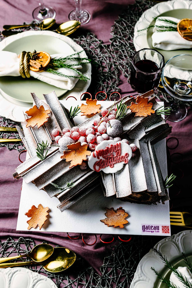Beautiful chocolate log cake decorated with festive leaves and berries, perfect for holiday celebrations