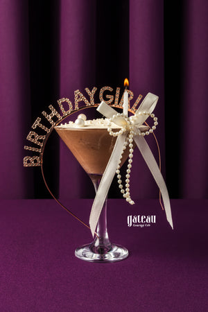 Chocolate mousse birthday dessert in a glass with a lit candle and birthday girl decoration by Gateau Gourmet Cafe