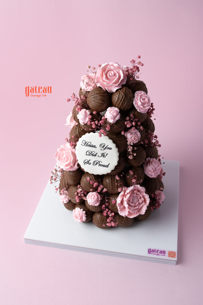 Chocolate truffle tower cake decorated with pink roses and a heartfelt message for celebrations