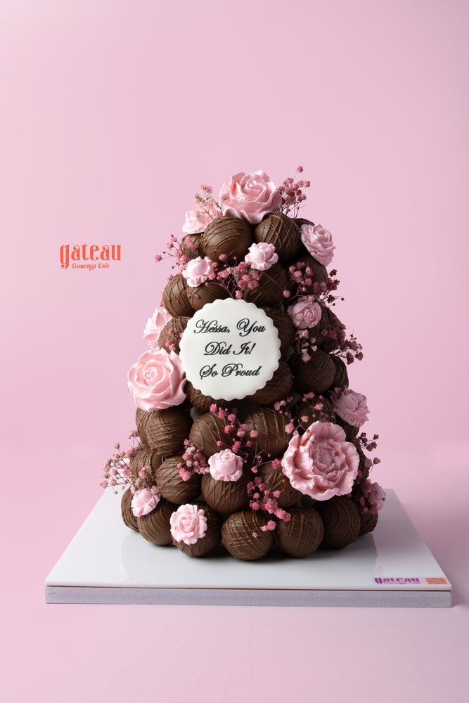 Elegant chocolate truffle tower cake decorated with pink roses and delicate flowers for special celebrations