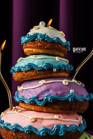 Colorful choux pastries stacked on a decorative choux pastry stand with blue and white icing details