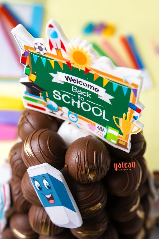 Colorful classroom theme cake featuring a 'Welcome Back to School' sign and decorative toppings