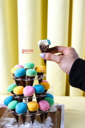 Colorful cupcakes for summer party displayed on a tiered stand with a hand holding one cupcake
