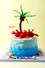 Crab birthday cake design by Gateau Gourmet Cafe featuring red crabs, a palm tree, and ocean waves decoration