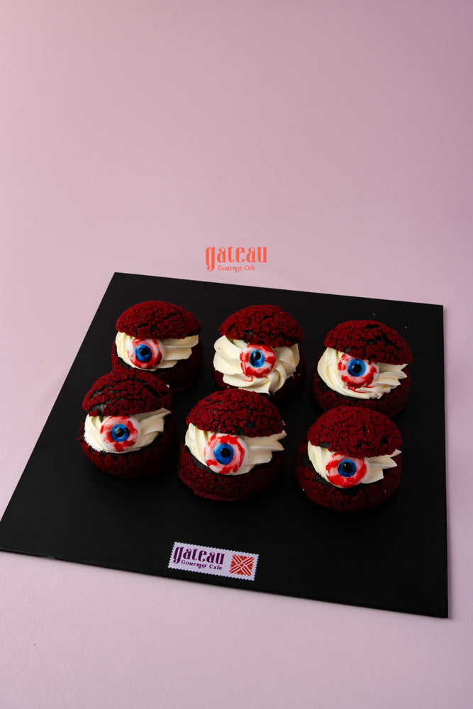 Red velvet creamy choux pastry treats topped with cream and decorative icing from Gateau Gourmet Cafe