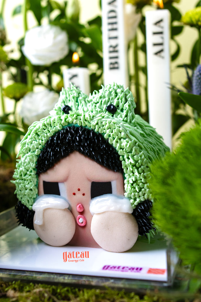 CRYBABY cake limited edition by Gateau Gourmet Cafe featuring a green frog hat and crying character design