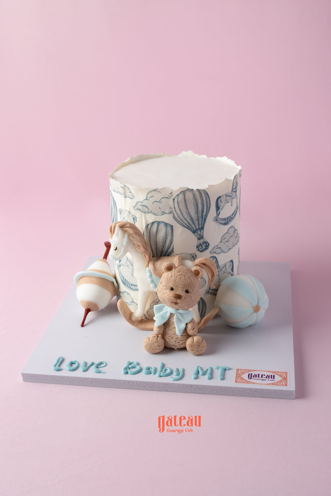 Custom baby shower cake with hot air balloon design and a cute teddy bear decoration