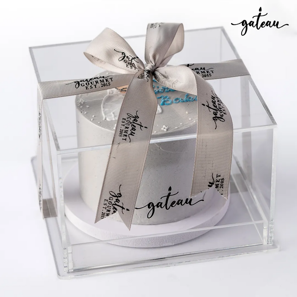 Gateau Gourmet Cafe custom birthday cake in clear box with branded ribbon and decorative white frosting
