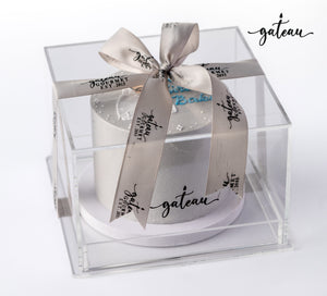 Gateau Gourmet Cafe custom birthday cake with white frosting in clear display box tied with branded ribbon