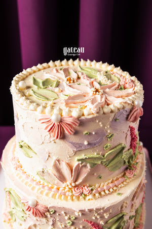 Gateau Gourmet Cafe custom birthday cakes with intricate pastel floral icing decorations on two tiers
