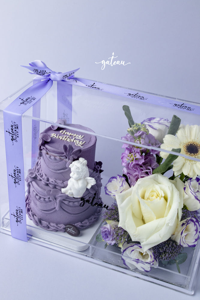 Gateau Gourmet Cafe custom cake arrangements with purple birthday cake and white and purple floral bouquet in clear gift box