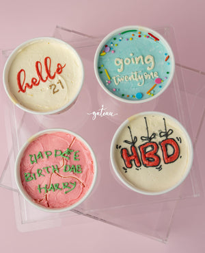 Four colorful custom cake to go from Gateau Gourmet Cafe with fun birthday messages on pink background