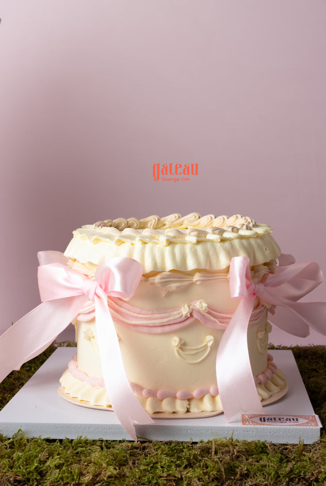 Beautiful custom cake with floral arrangement from Gateau Gourmet Cafe topped with elegant ribbons