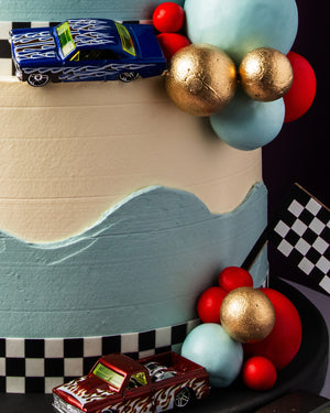 Colorful custom cakes for boys featuring racing cars and vibrant decorations
